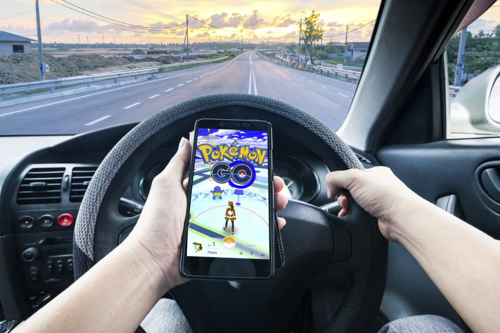 California, United States, - July 16, 2016: A man is dangerously playing Pokemon Go while driving and tried to catch the 