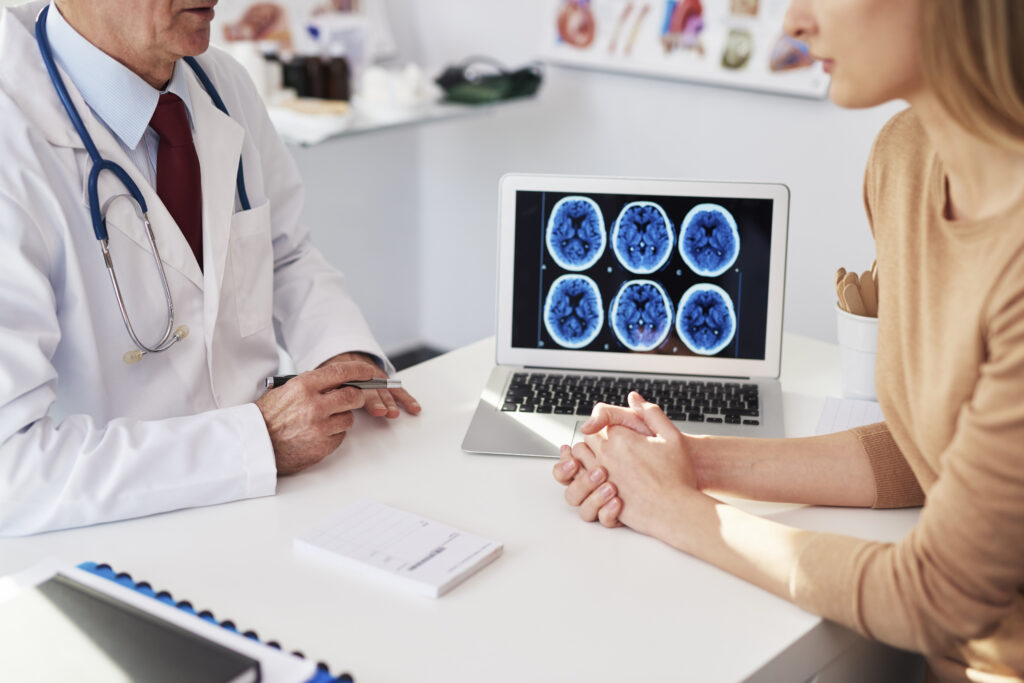 Benign meningioma consultation showing brain scan and discussion of hormone-related tumor risks