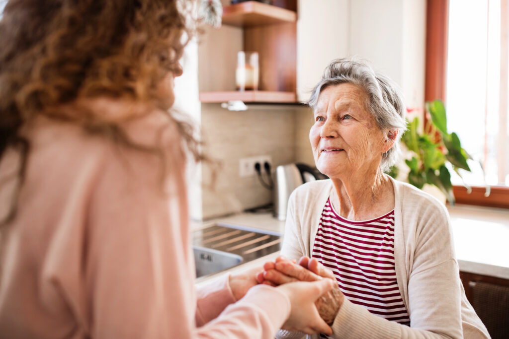 An adult daughter holding an elderly parent’s hand, symbolizing family support and peace of mind during Injectafer legal consultations.