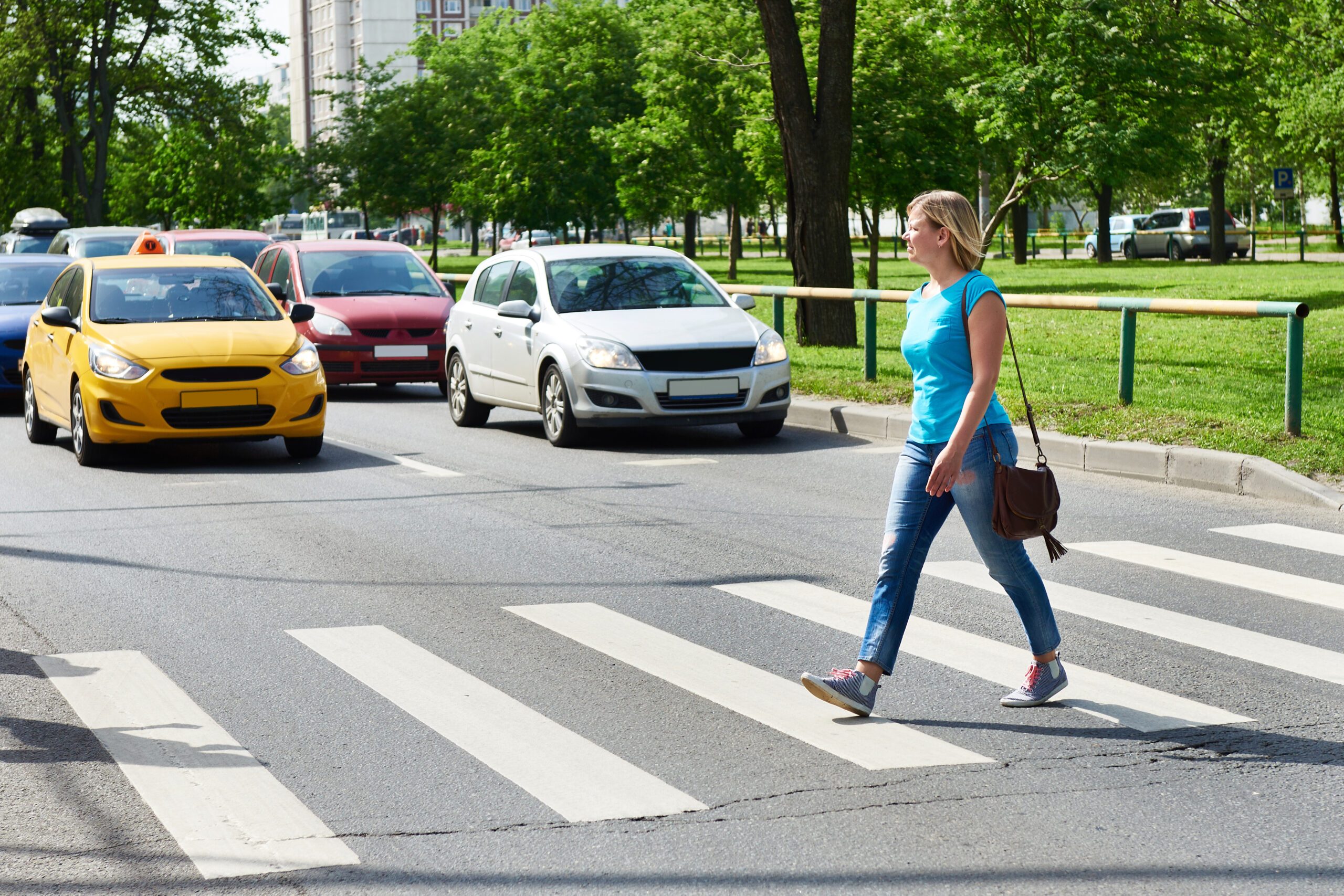 Woman crossing a busy street in front of stopped traffic before an Atlanta pedestrian accident occurs.