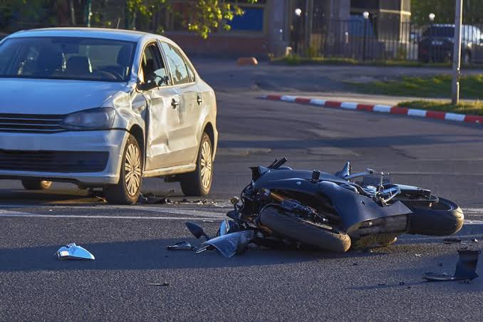 Wrecked motorcycle beside a dented sedan after a crash with an uninsured motorist in Birmingham